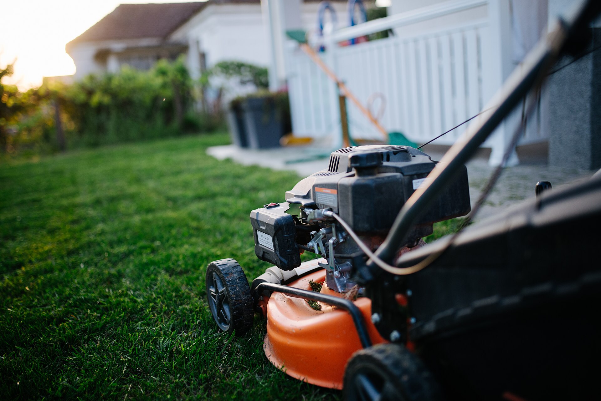 A lawn mower on a freshly cut lawn at dusk